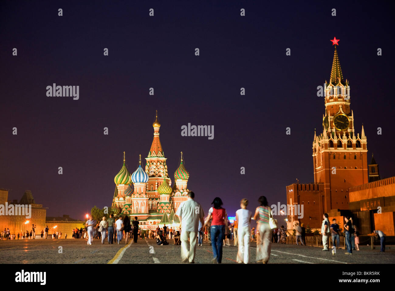 Russia, Moscow;  Muscovites and tourists, Red Square, with a clock tower from the Kremlin and St.Basil's Cathedral Stock Photo