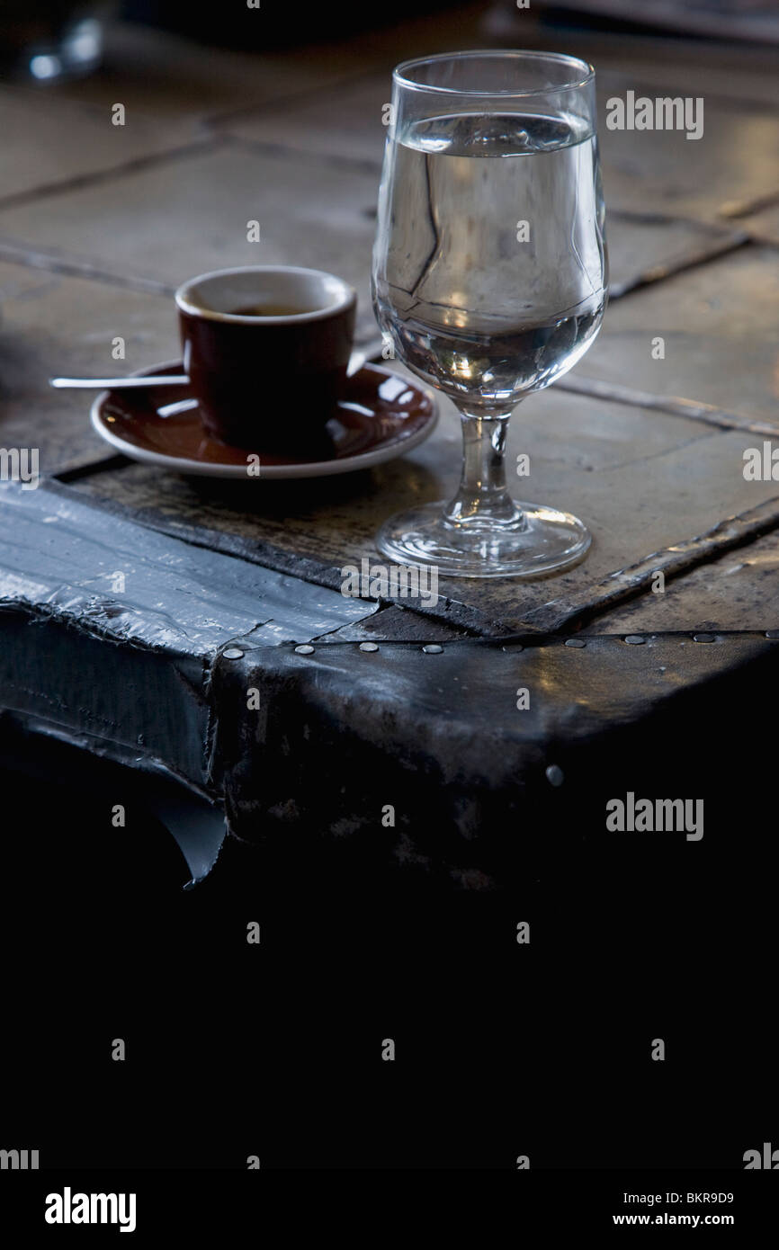 A Glass Of Water With A Cup And Saucer Sitting On An Old Trunk Stock