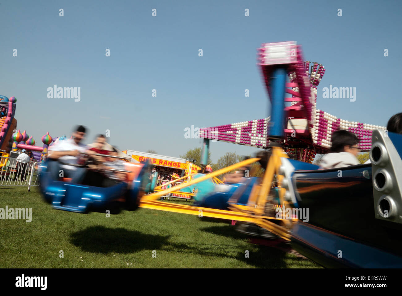 Blurry view of riders on a spinning fair ground ride at a fun fair in