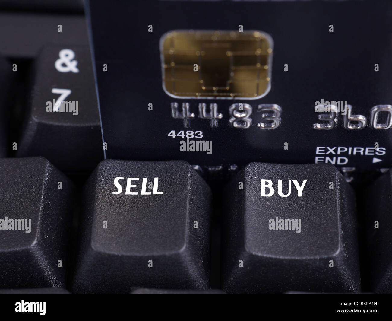 Closeup of two black keyboard keys with Sell and Buy words and microchip credit card in the background Stock Photo