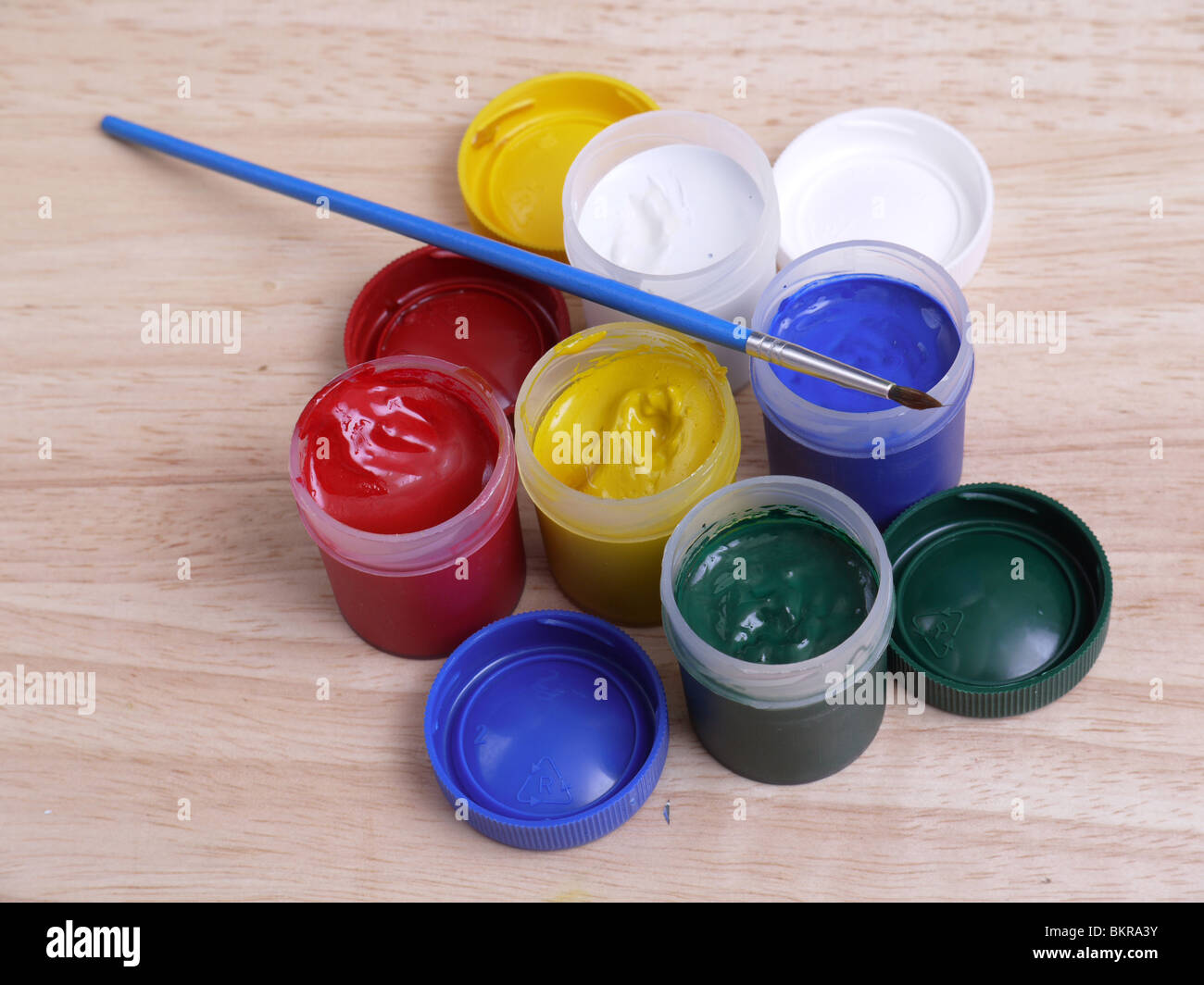 Set of five color art paint tubes with paintbrush on wooden table Stock Photo
