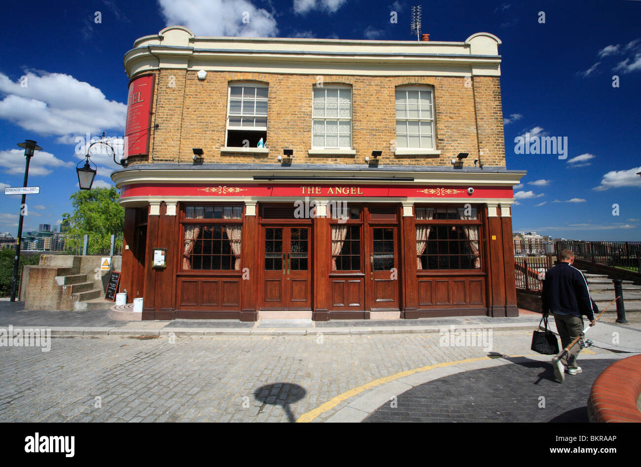The Angel PH, Bermondsey Wall East, London. A river side pub with a fisherman walking past Stock Photo
