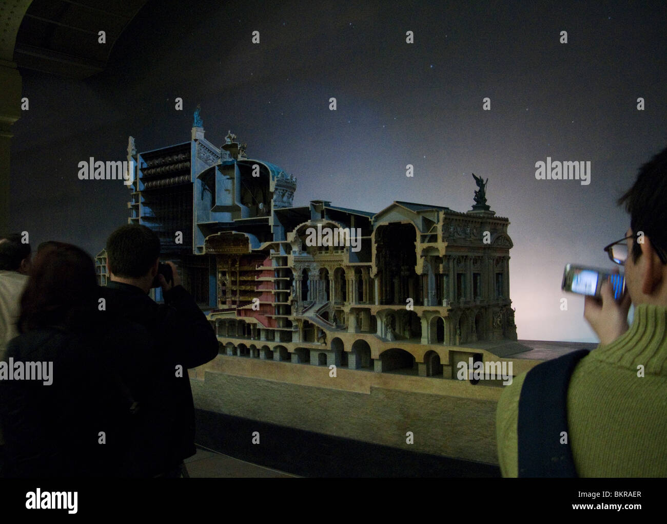 Tourists photographing a model of the Paris Opera House in the Musee D'Orsay, Paris, France. Stock Photo