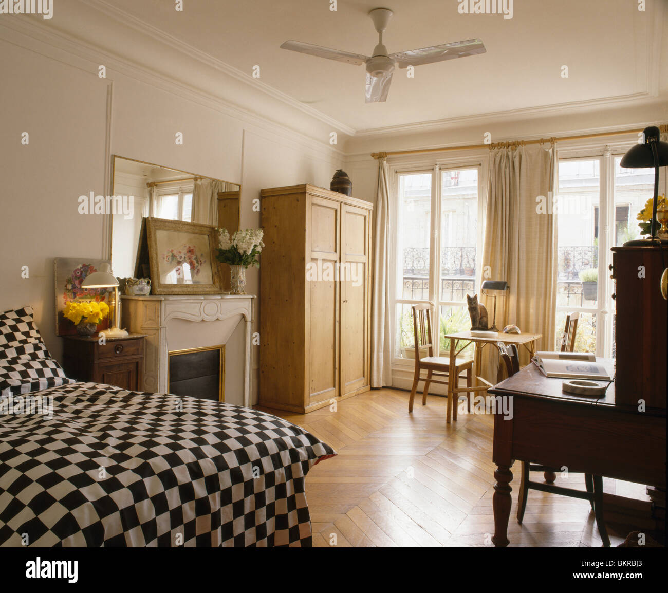 Black+white checked bedcover on bed in French apartment bedroom with