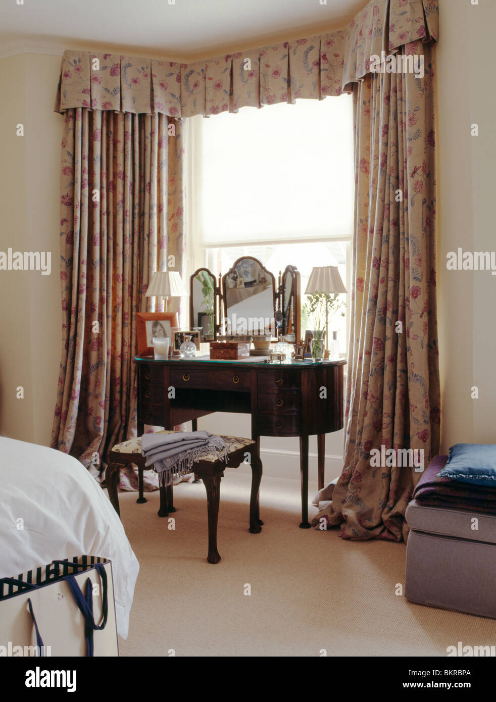 Antique Dressing Table In Front Of Window With Patterned Curtains