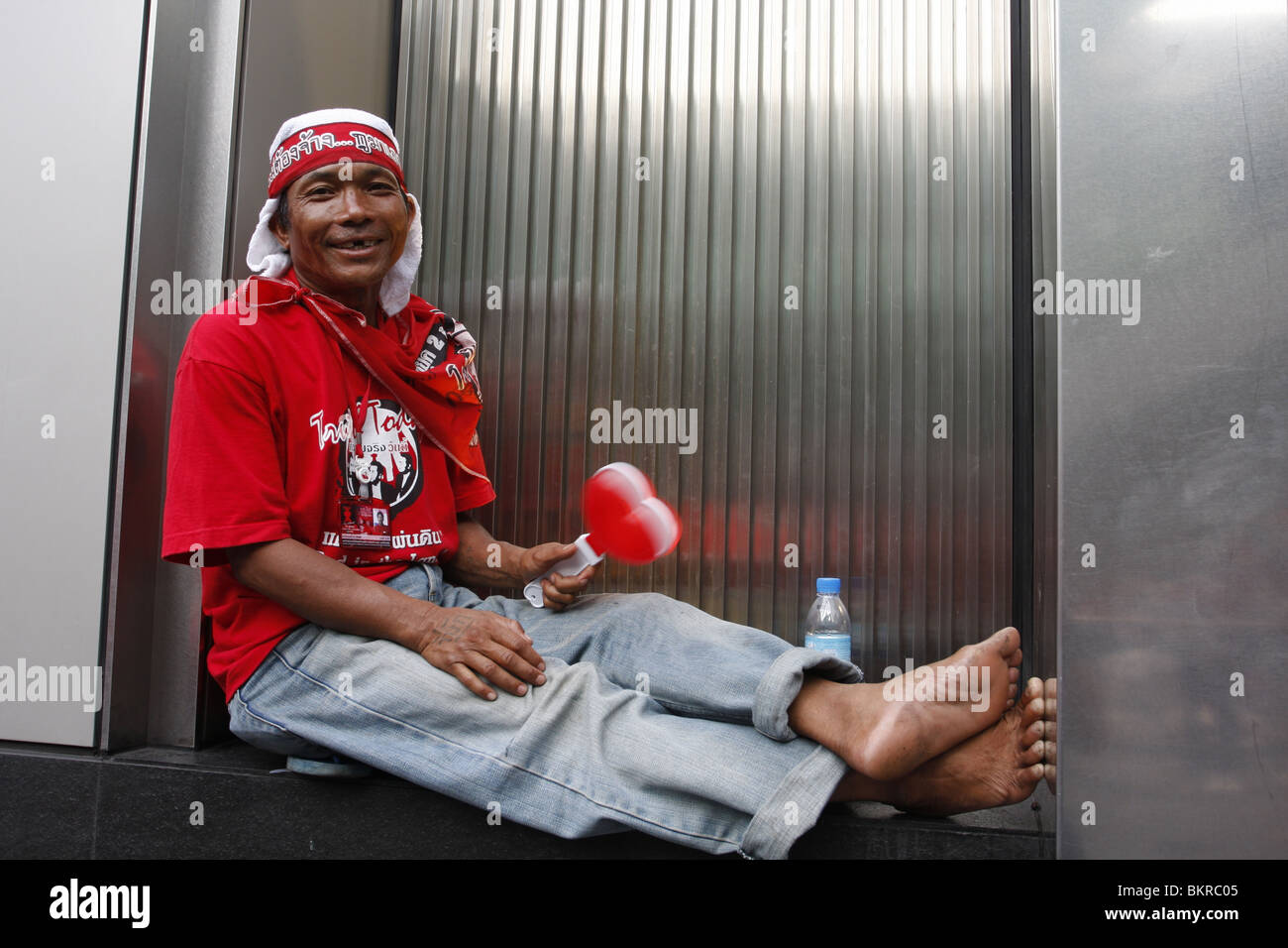 A Red shirt demonstrator campaigning for the return of disgraced PM Thaksin Shinawatra, takes a rest in central Bangkok. Stock Photo
