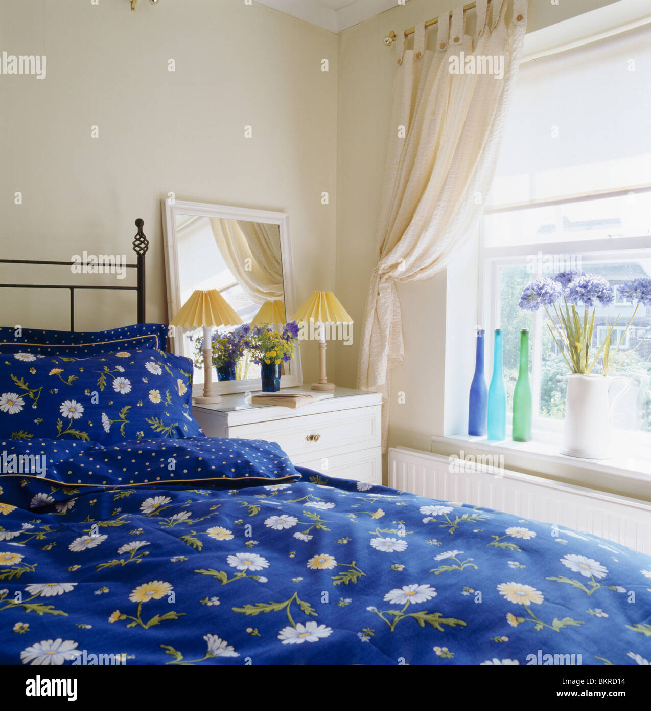 Patterned Blue Bedlinen On Bed In Small Bedroom With Cream