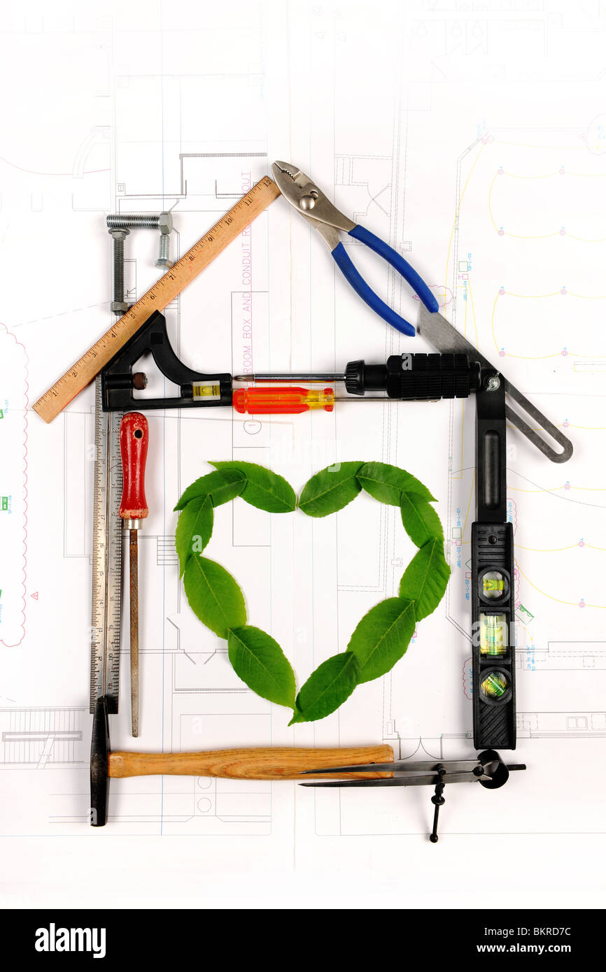 House made of tools with heart formed by leaves in the middle Stock Photo