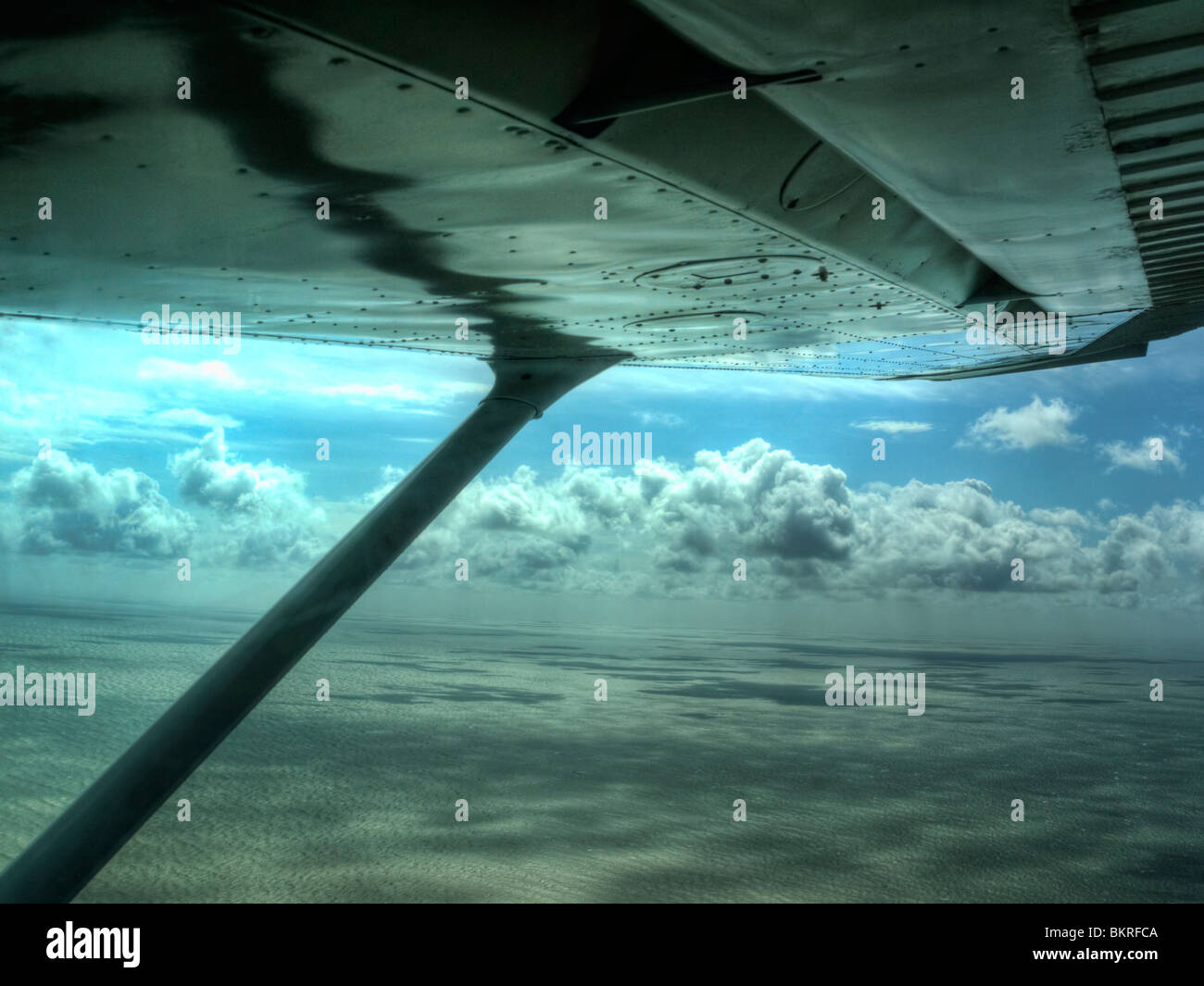 Looking out from under the wing of a light aircraft at the clouds during a very bumpy flight over the sea in West Sussex. Stock Photo