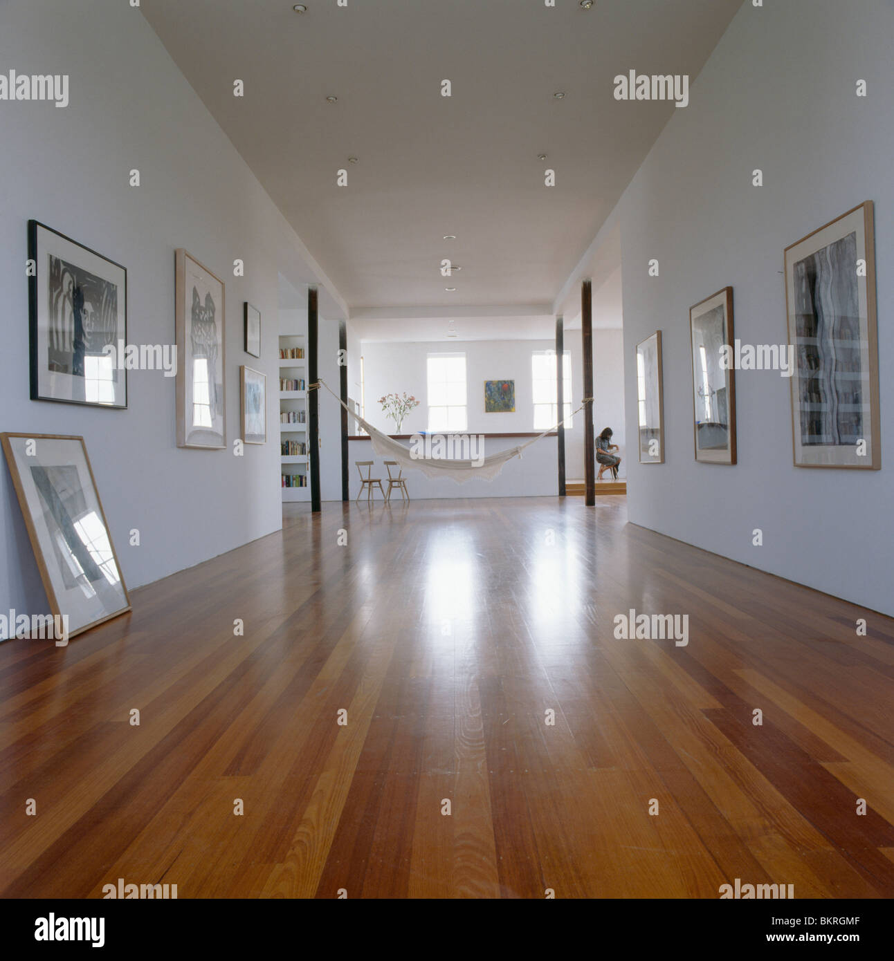 Wooden flooring in large modern loft conversion hall with collection of