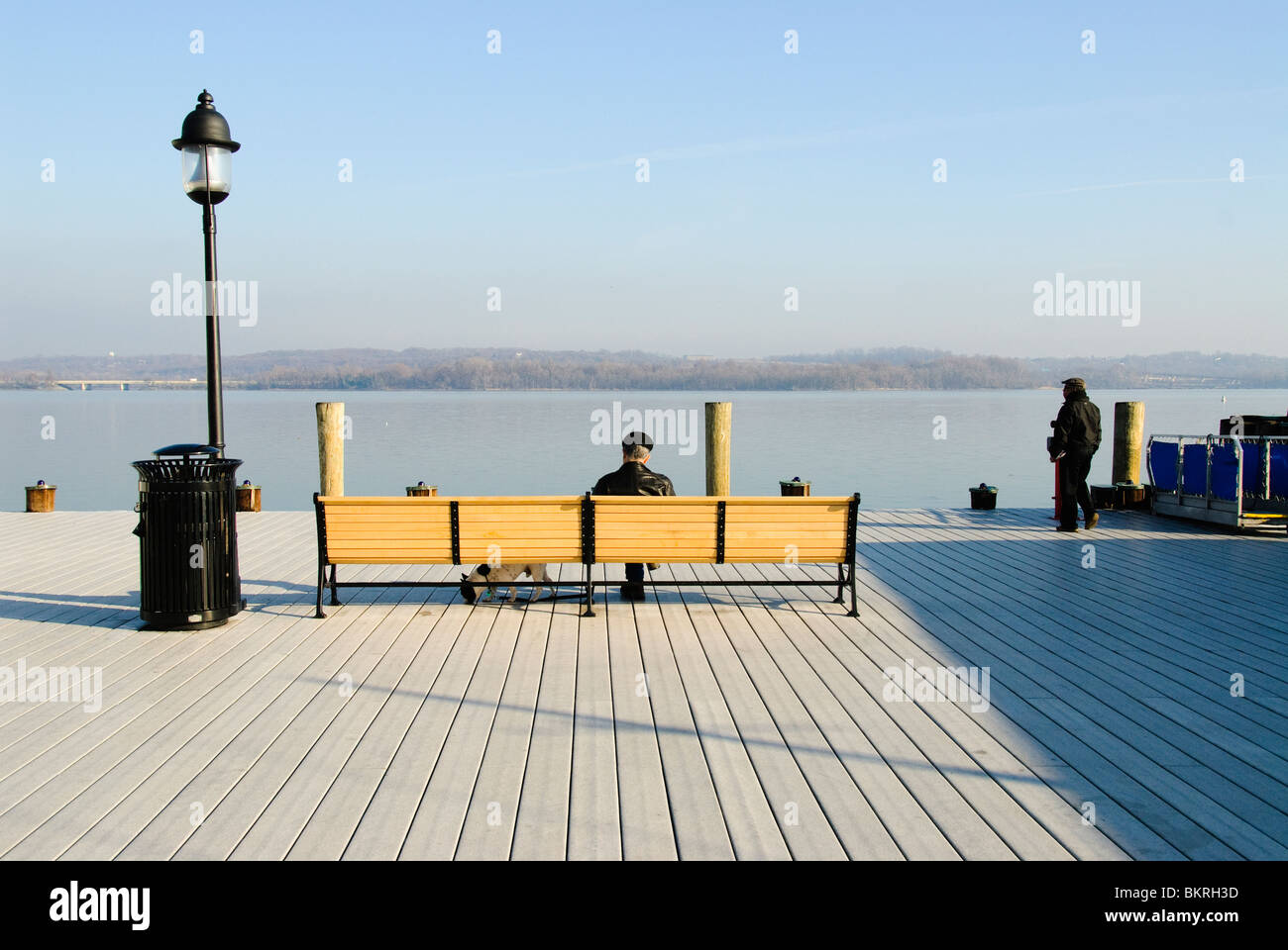 ALEXANDRIA, Virginia Man with his dog sitting on a bench at the Old