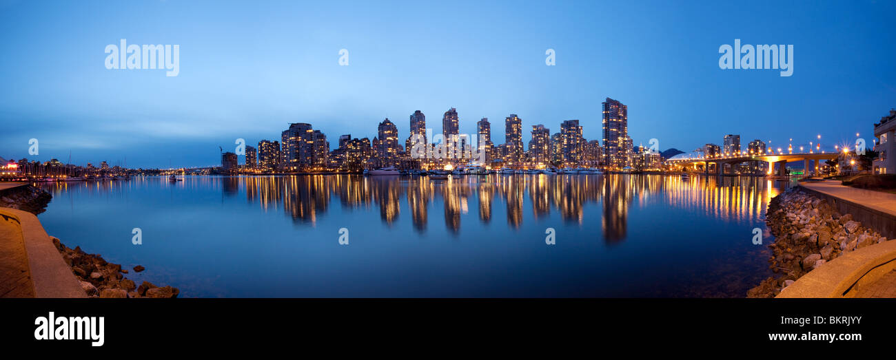 False creek framed by the Vancouver Seawall reflects the lights of Yaletown apartment complexes and BC Place Stadium on the Vancouver downtown Skyline Stock Photo
