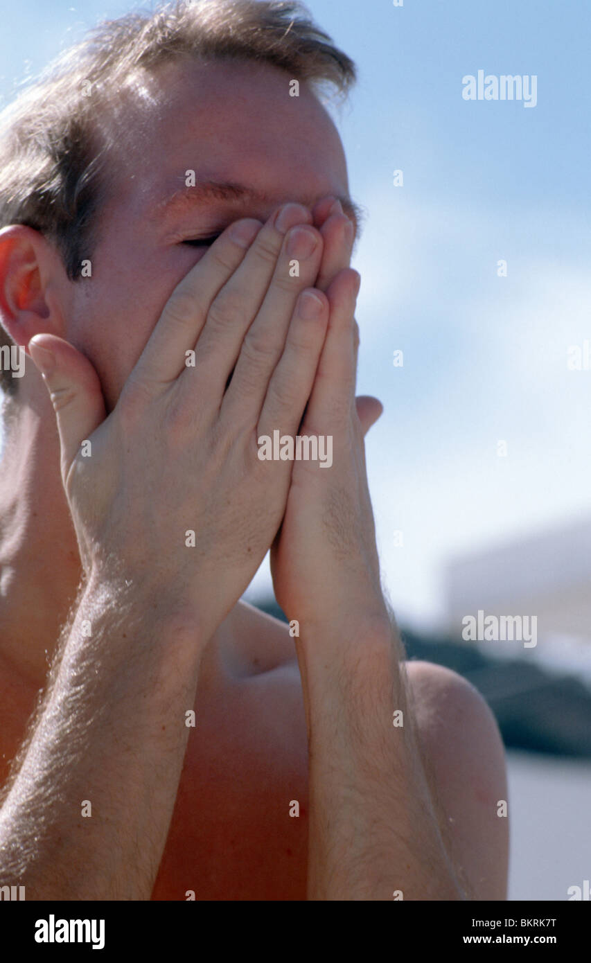 Man put tanning oil on face Stock Photo Alamy