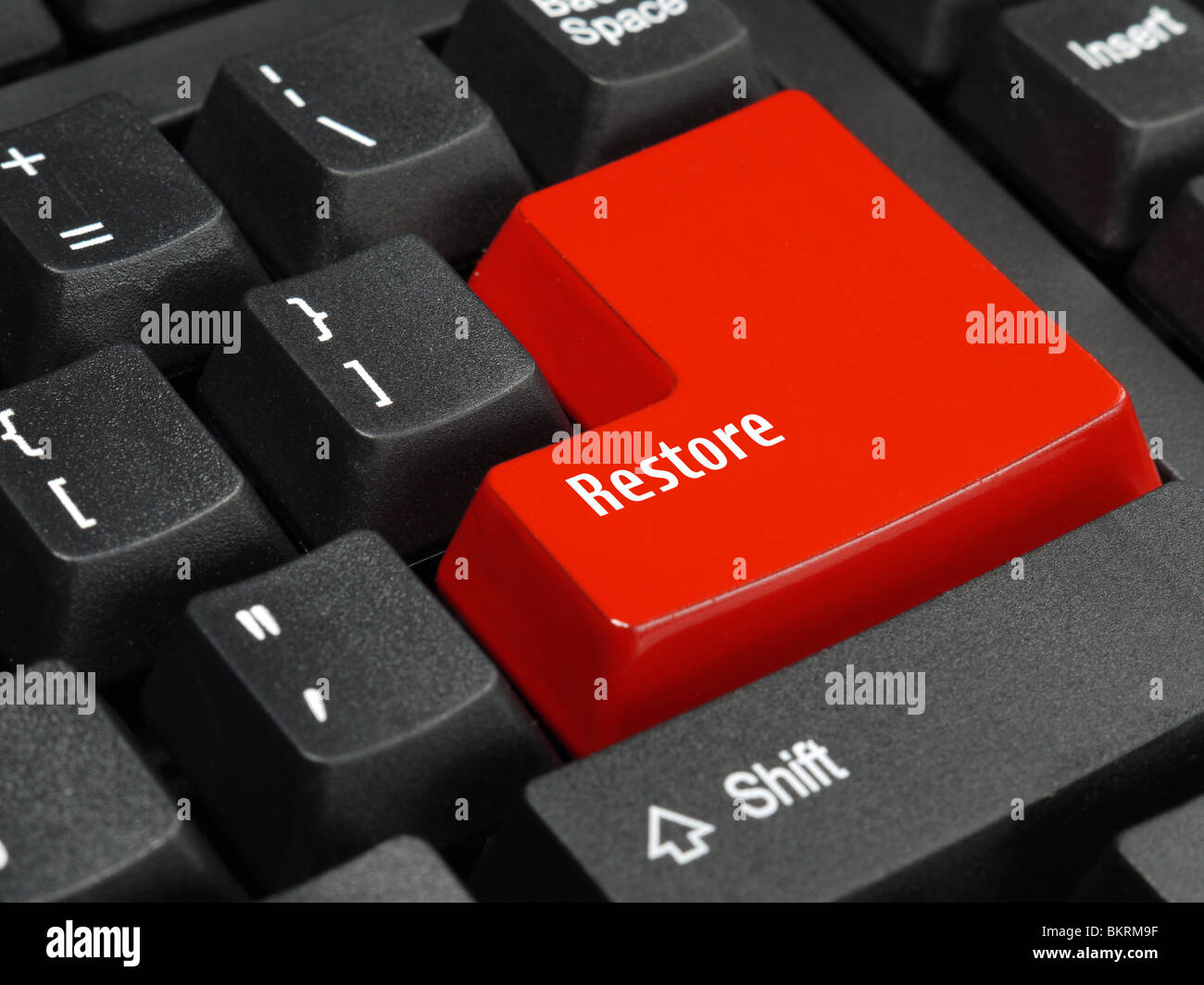 Closeup of computer keyboard key in red color spelling Restore Stock Photo