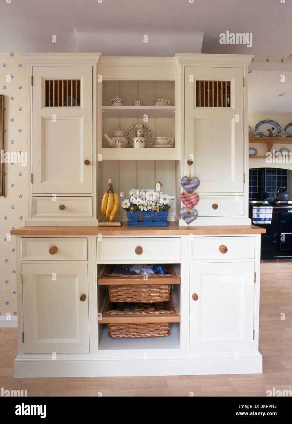 Cream fitted kitchen dresser with integral storage baskets in country  kitchen Stock Photo - Alamy