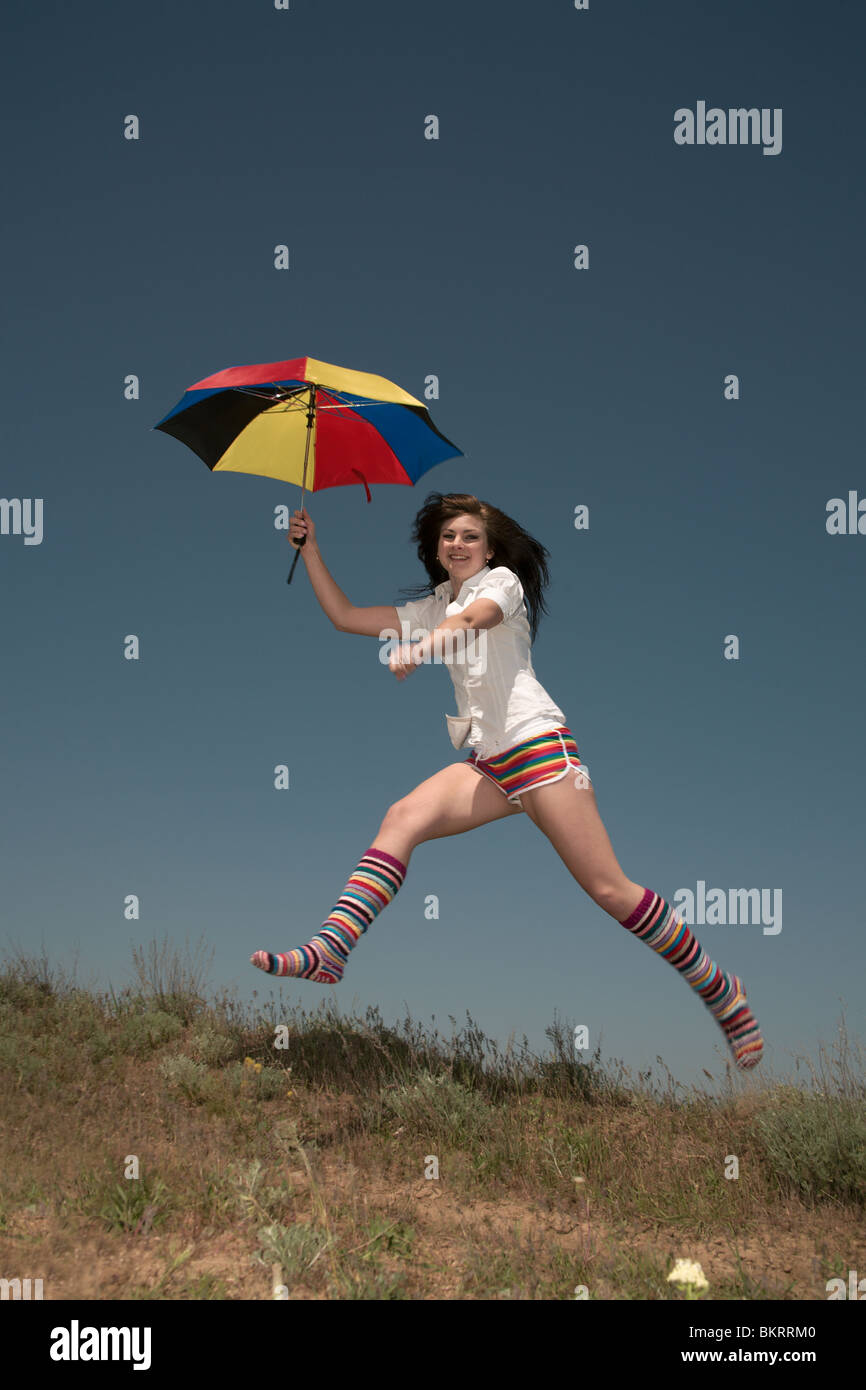 Girl with a color umbrella jumps highly upwards Stock Photo - Alamy