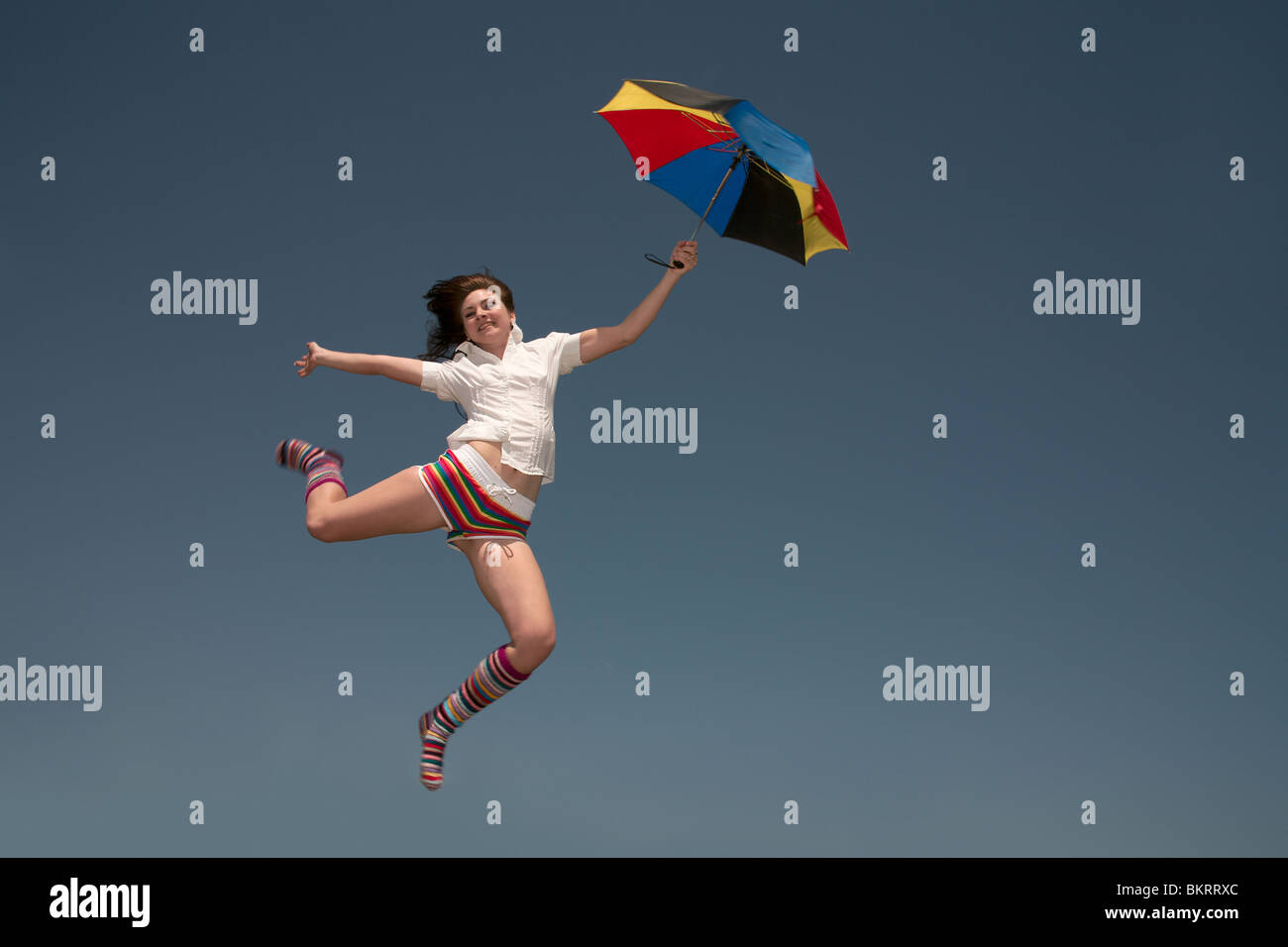 Girl with a color umbrella jumps highly upwards Stock Photo - Alamy