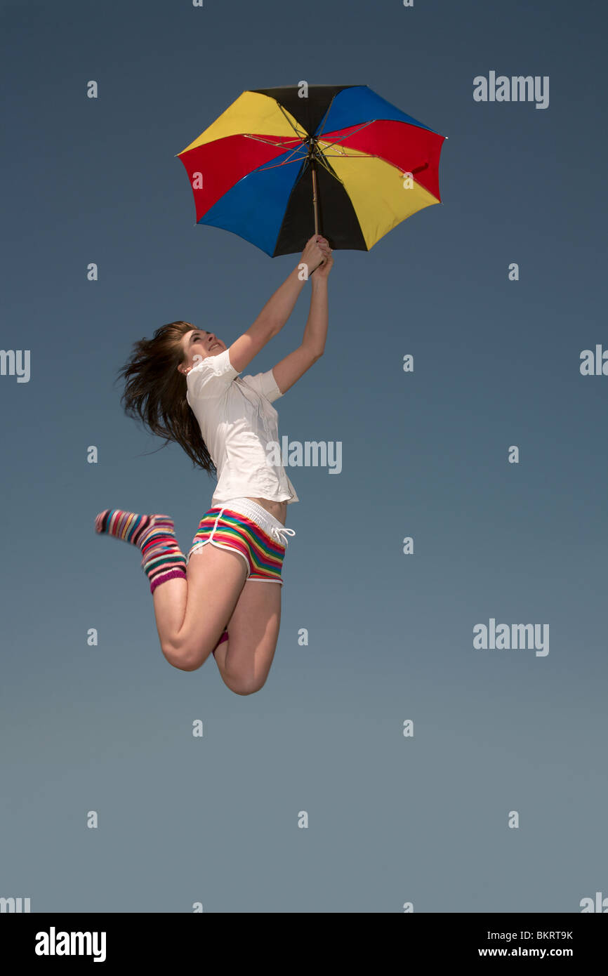 Girl with a color umbrella jumps highly upwards Stock Photo - Alamy