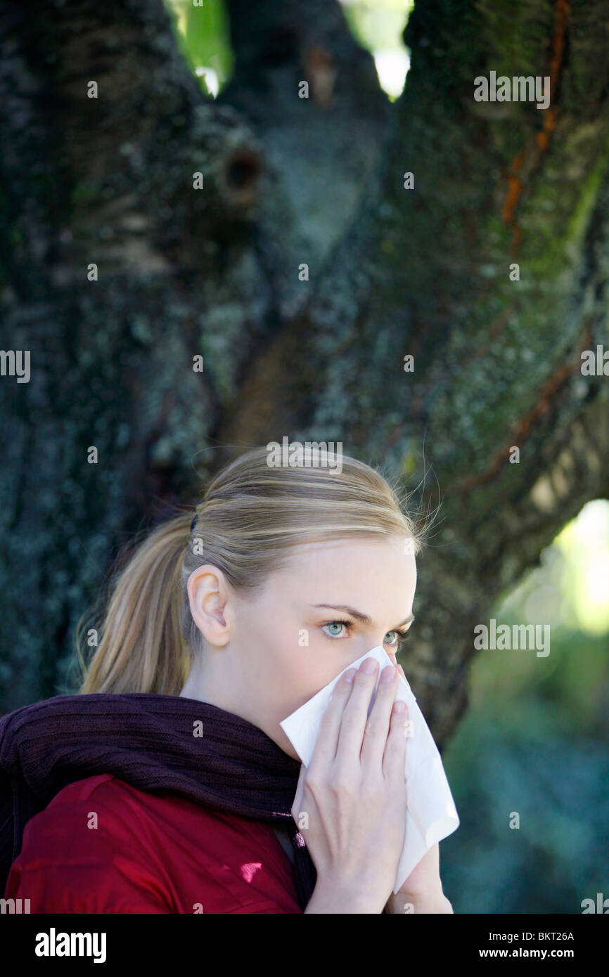 allergic girl blows her nose Stock Photo