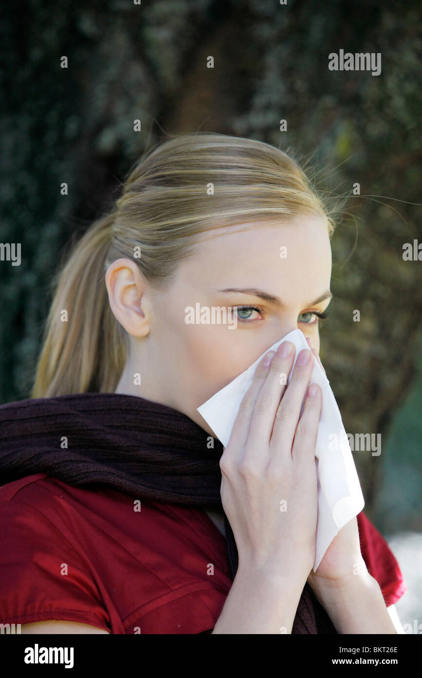 allergic girl blows her nose Stock Photo