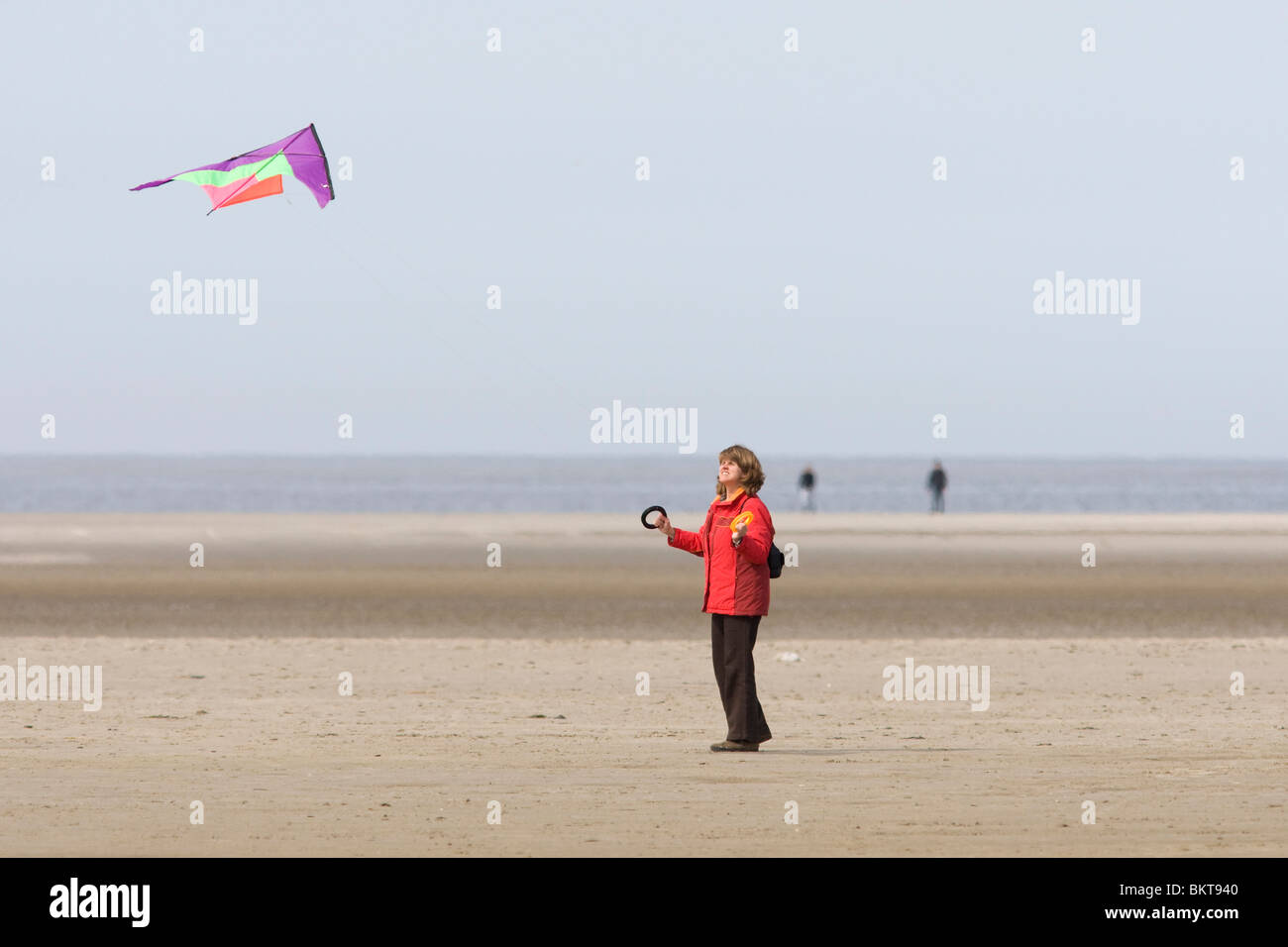 A woman is flying a kite at the beach Stock Photo Alamy