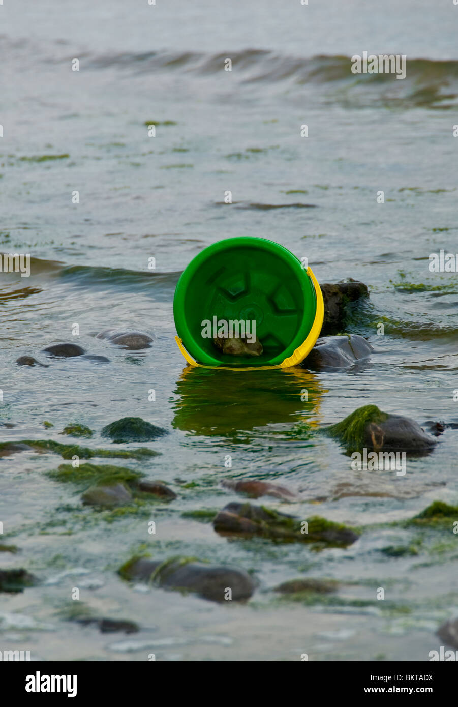 A plastic sand castle bucket in the sea Stock Photo Alamy