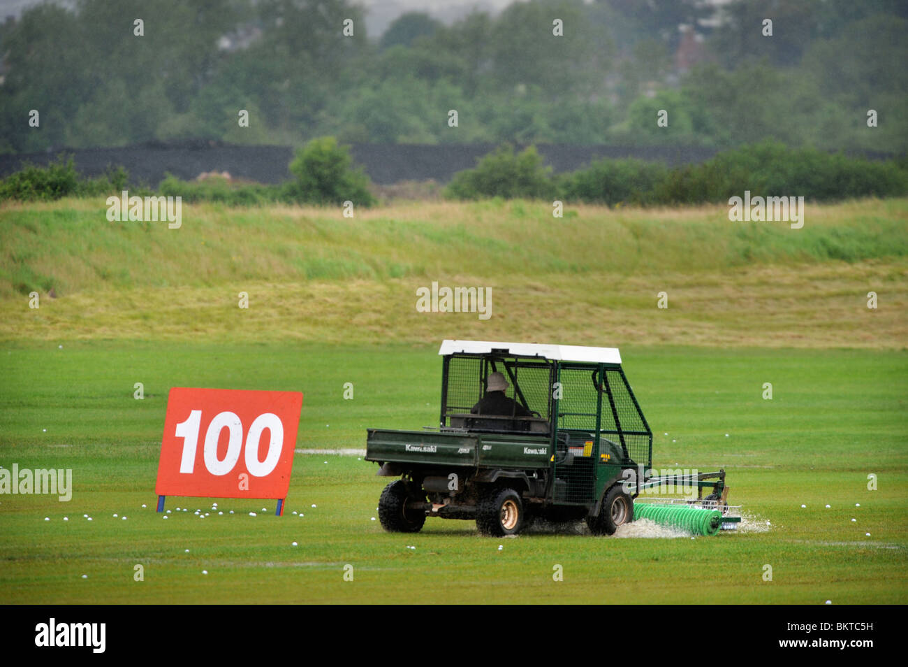 A golf ball collector on the rainswept driving range at the Celtic