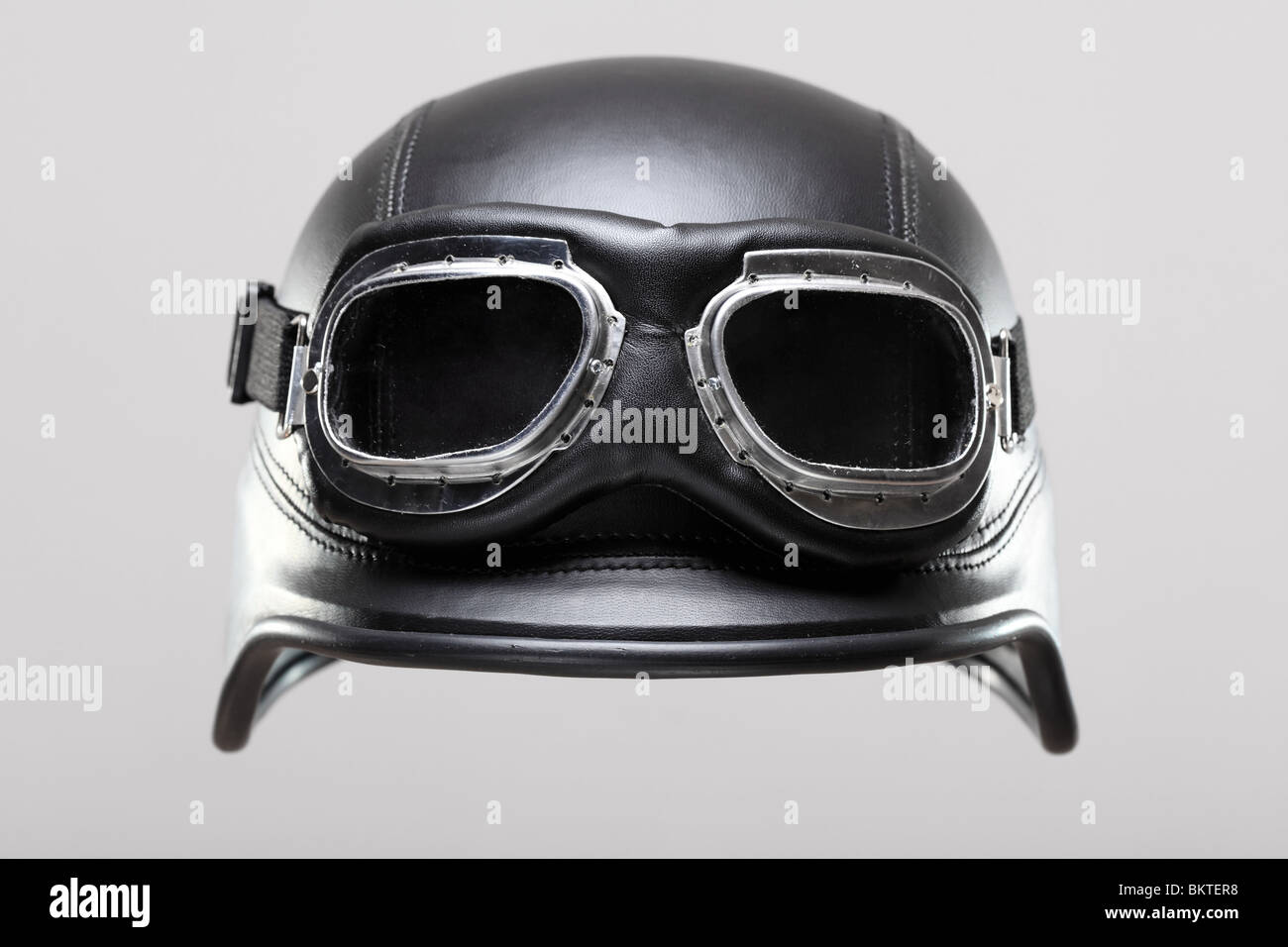 old-style us army motorcycle helmet with goggles, on gray background