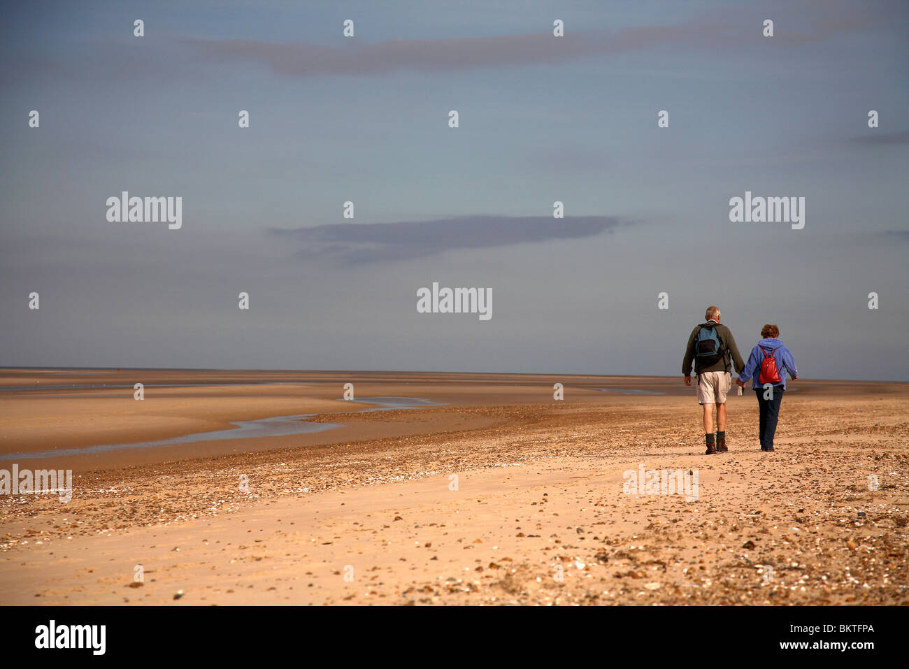 middle aged couple walking on beach Stock Photo