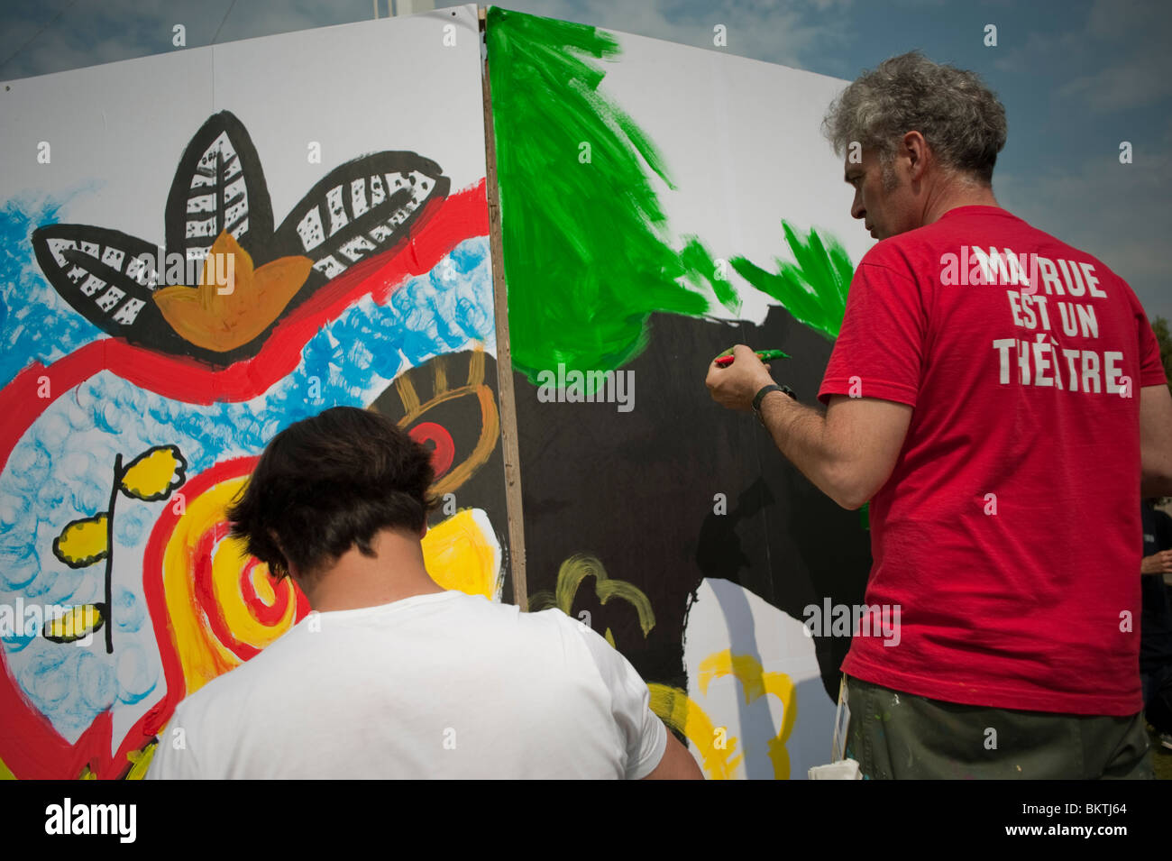 Celebration of World "Fair Trade" Day, Lawn of La Villette Park, Men Painting Wall Graffiti Stock Photo