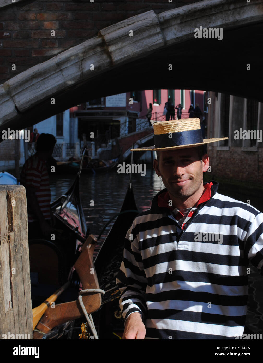 Gondolier under bridge, Venice, italy Stock Photo