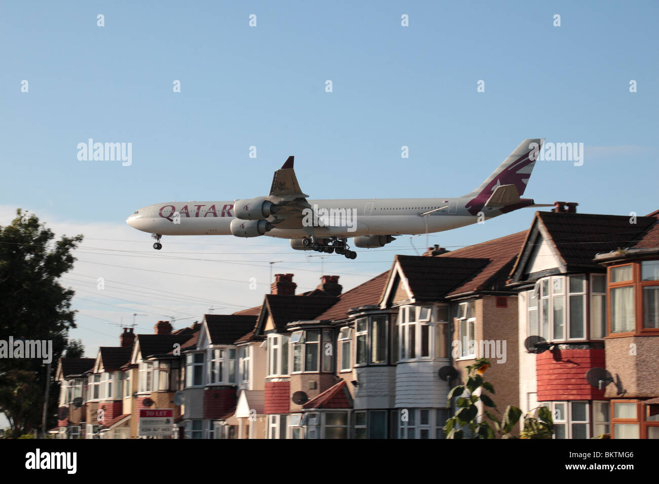 A Qatar Airbus A340-642 landing at Heathrow Airport, London, UK. View from Myrtle Avenue, Hounslow. (A7-AGC) Stock Photo
