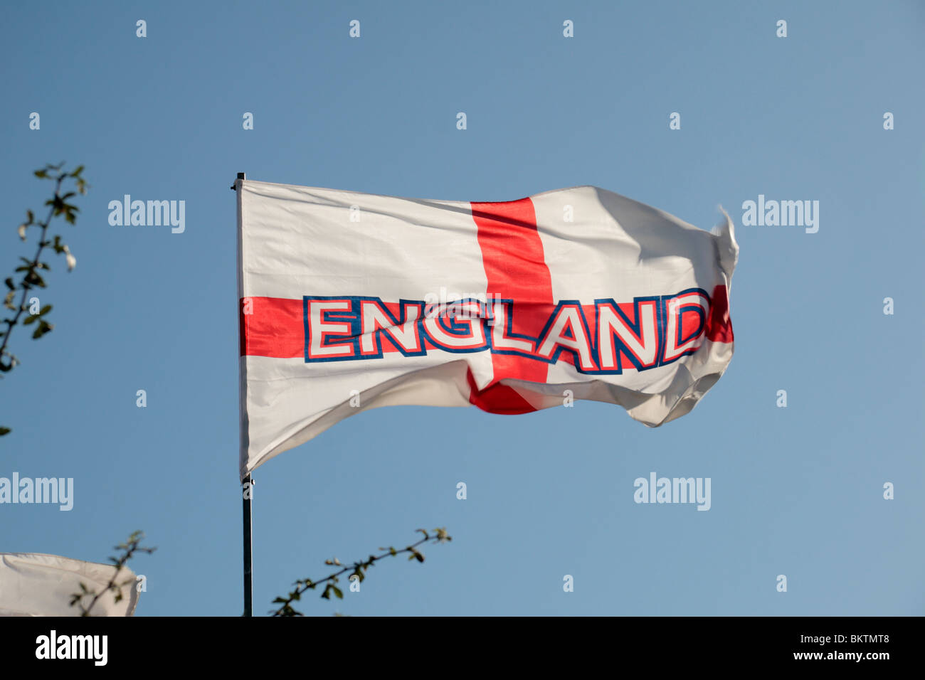 An England Cross of St George flag flying against a blue sky. Stock Photo