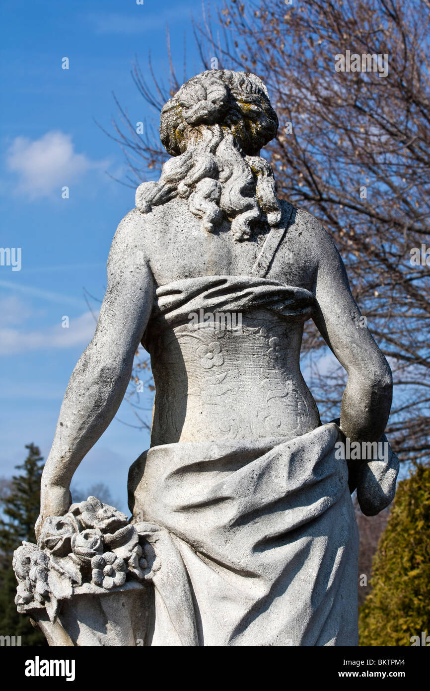 Stone sculpture statue woman back in city park close up closeup focus USA America against blue sky nobody hi-res Stock Photo