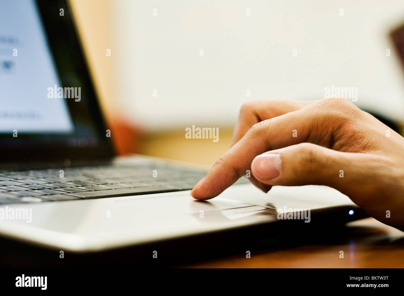 Student's finger on trackpad of wi-fi laptop computer. Stock Photo