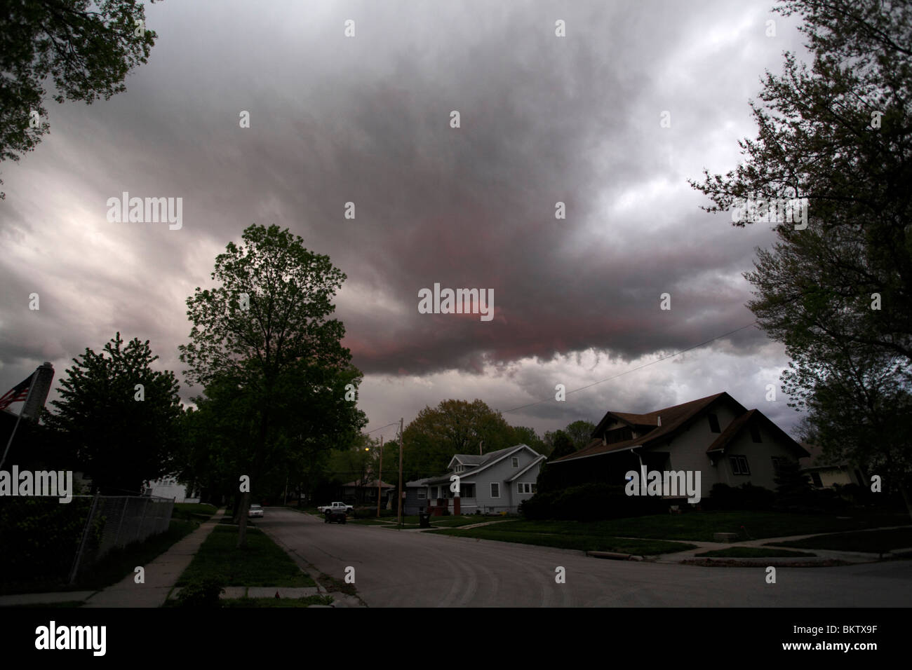 Red tinged clouds in a hanging wall, thunderstorm variety near sunset. Stock Photo
