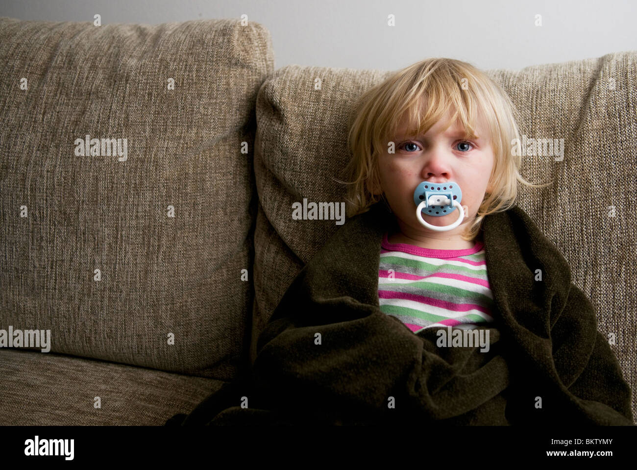 Girl sitting in sofa having a cold Stock Photo