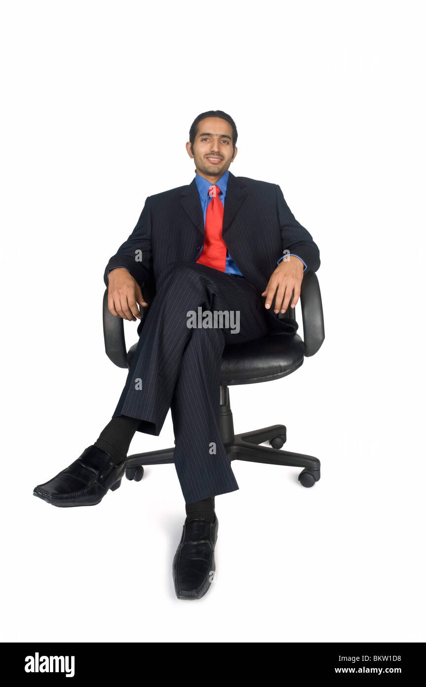 Businessman sitting on chair with legs crossed portrait Stock