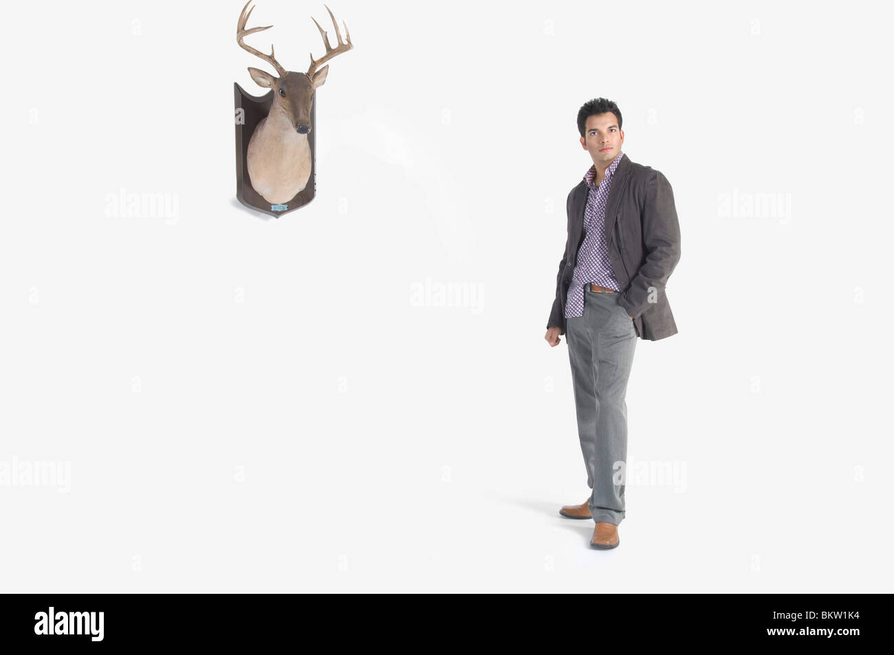 Young man standing by deer head Stock Photo
