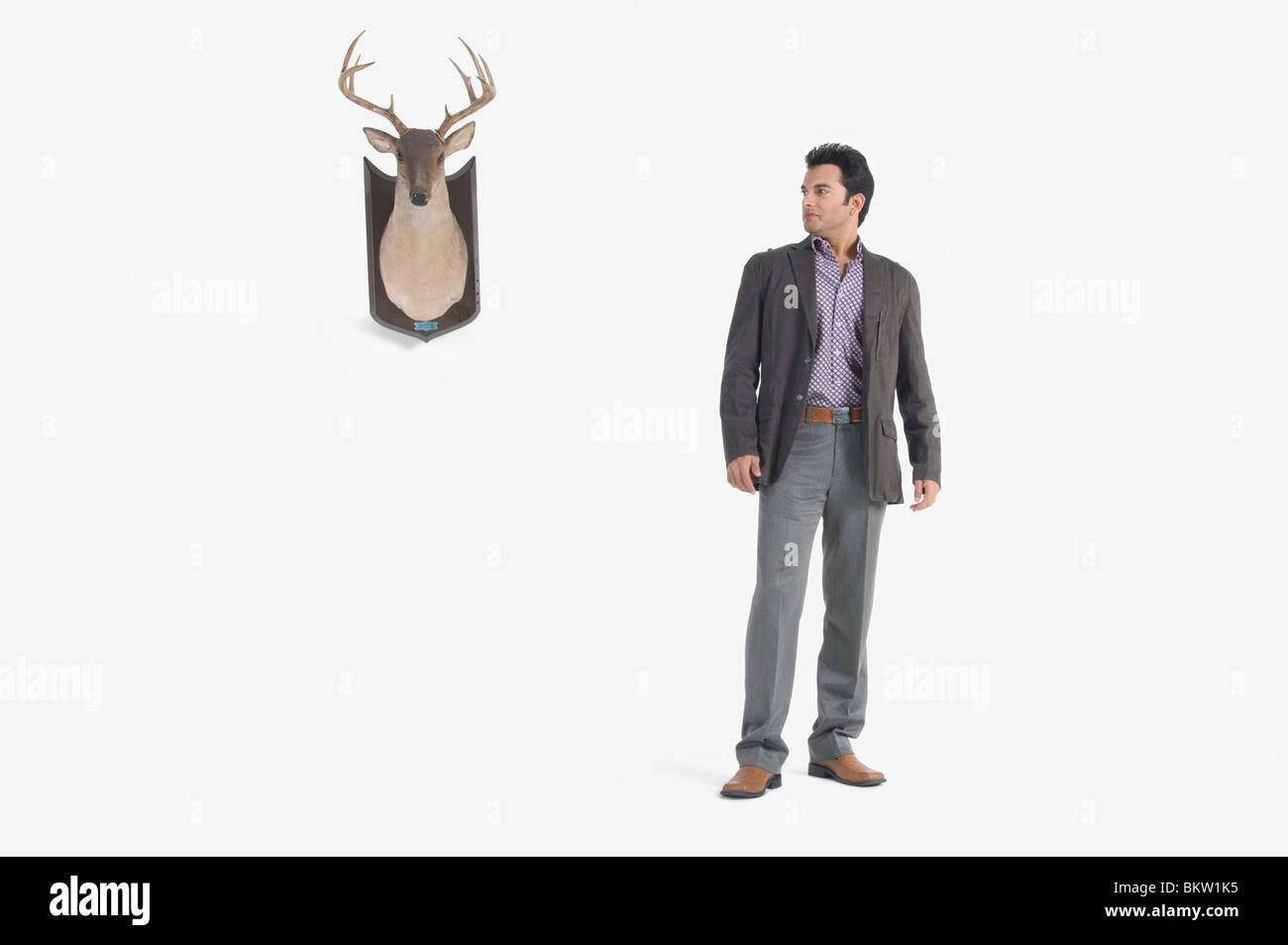 Young man standing by deer head Stock Photo