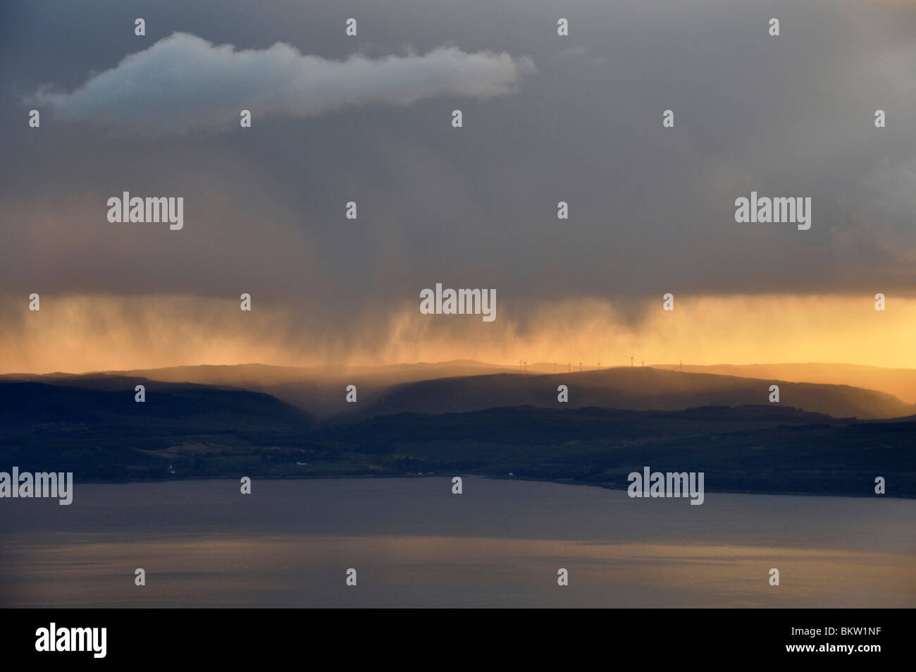 Dark rain clouds over Mull of Kintyre from Meall Bhig, Arran at sunset Stock Photo