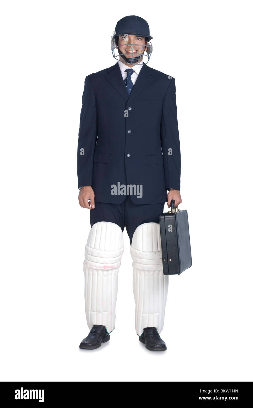 Businessman wearing sports helmet and cricket pad, portrait Stock Photo