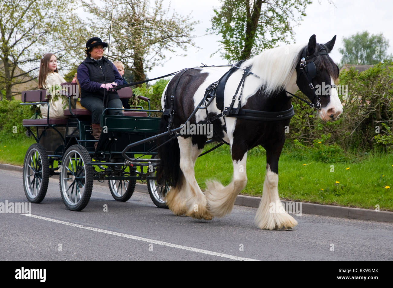 A pony and trap used to take the May Queen to her coronation in a cotswold village on Mayday. Stock Photo
