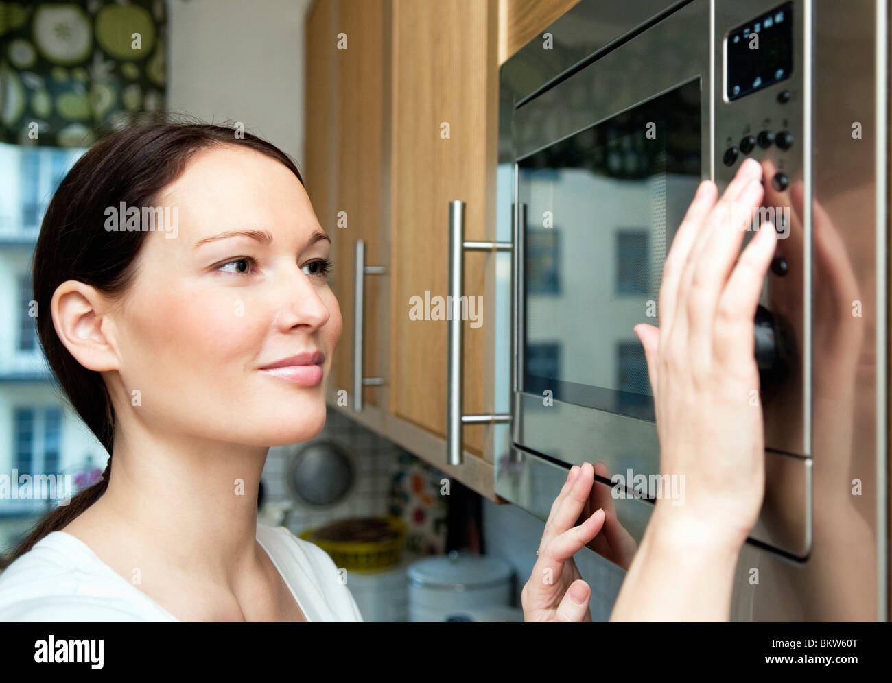 Woman using microwave oven Stock Photo