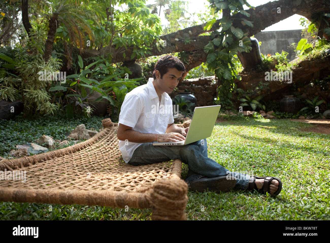 Man with laptop sitting in the garden Stock Photo - Alamy