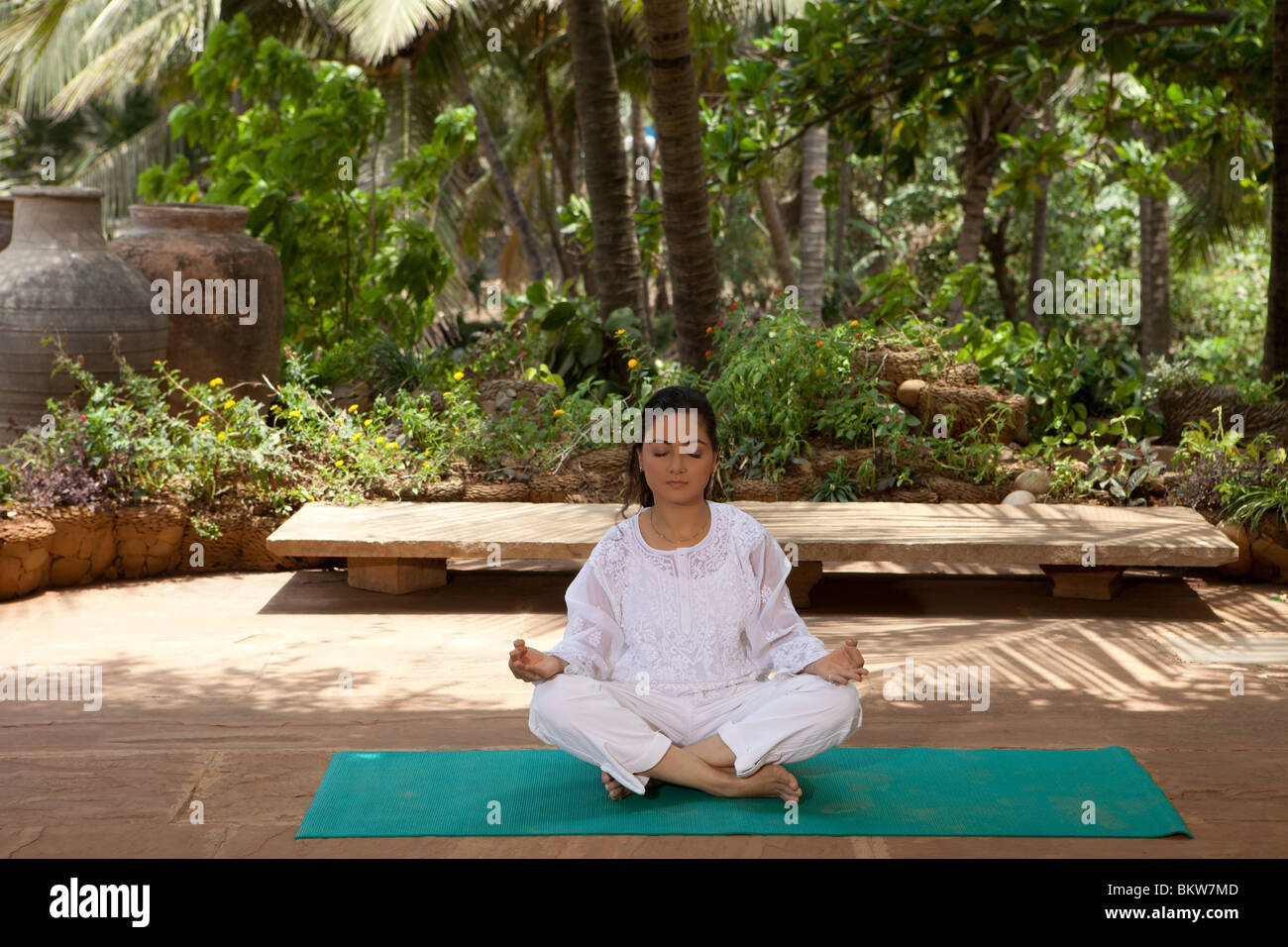Woman in lotus yoga position in the garden Stock Photo - Alamy