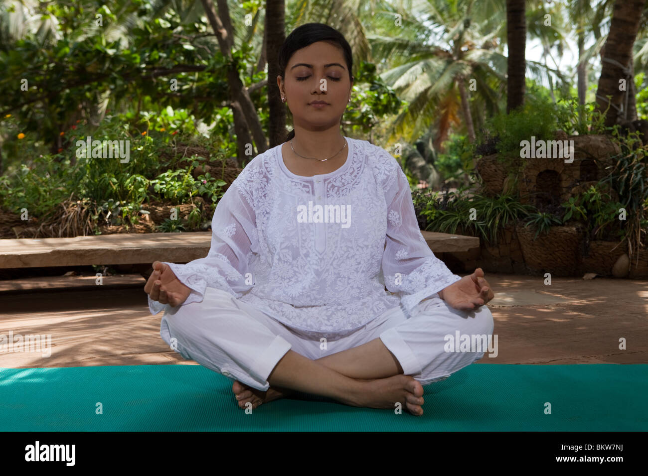 Woman in lotus yoga position in the garden Stock Photo - Alamy