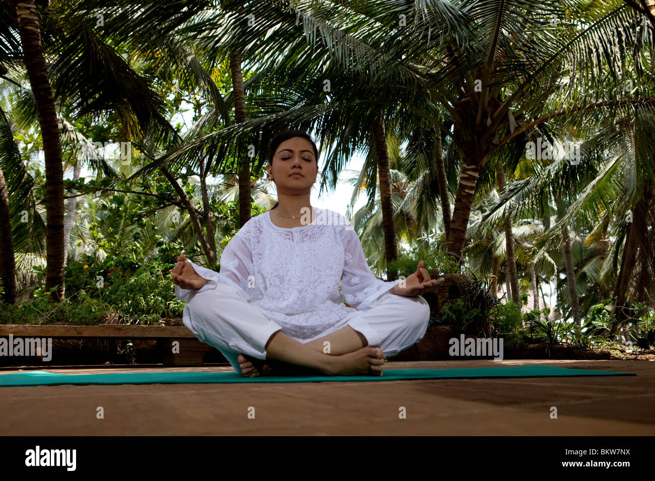 Woman in lotus yoga position in the garden Stock Photo - Alamy