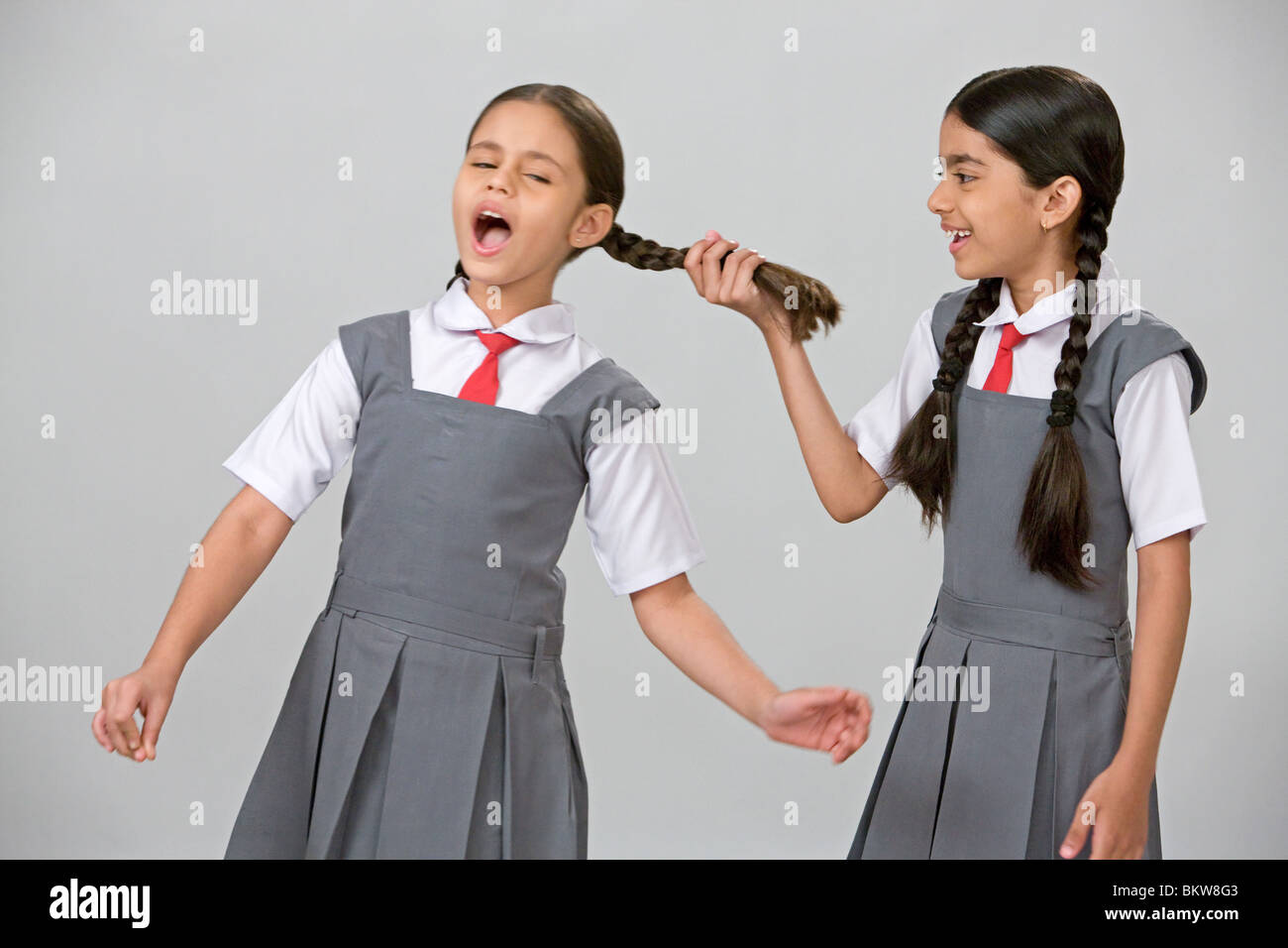 One naughty school girl pulling another girls hair Stock Photo Alamy