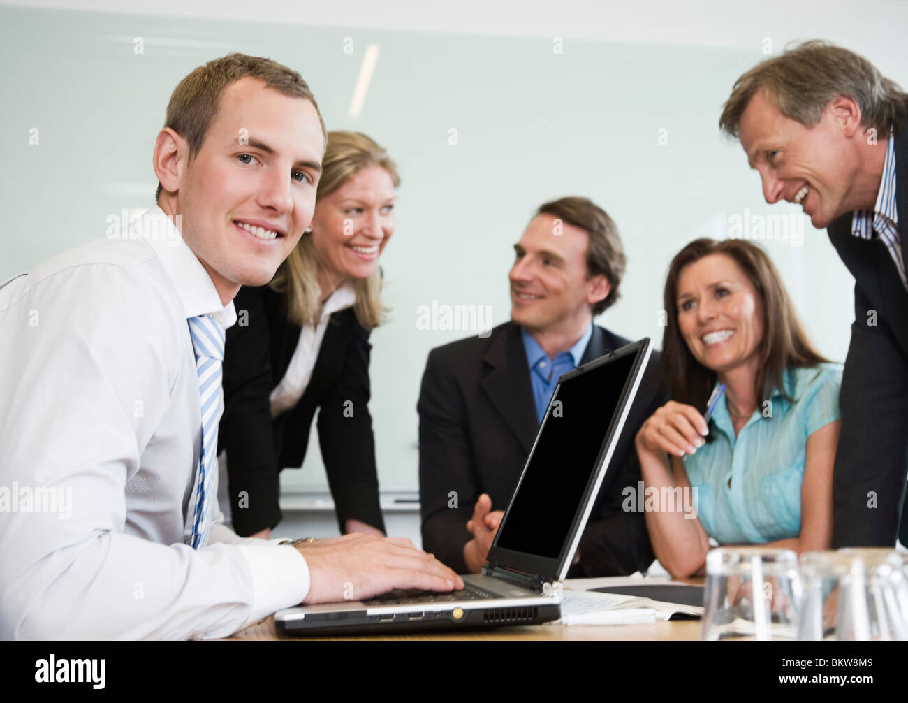 Five people by conference table Stock Photo